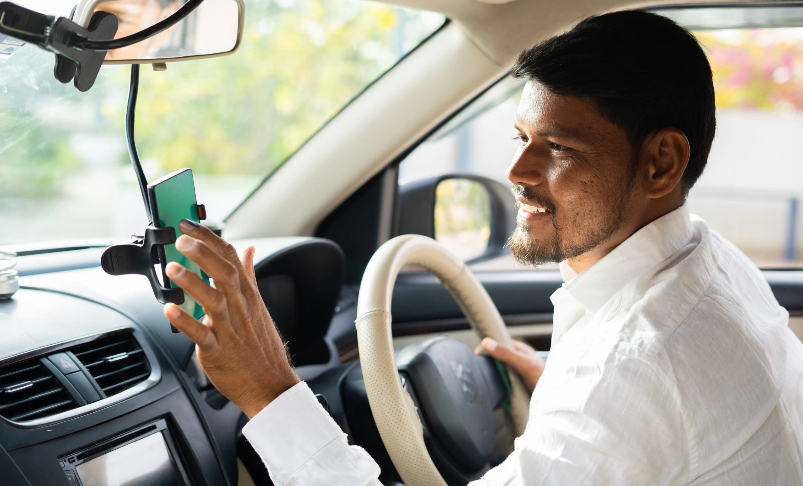 Gig worker driving with a phone mounted in the car